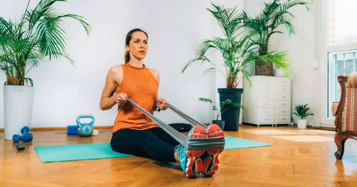woman doing rowing exercise in her room