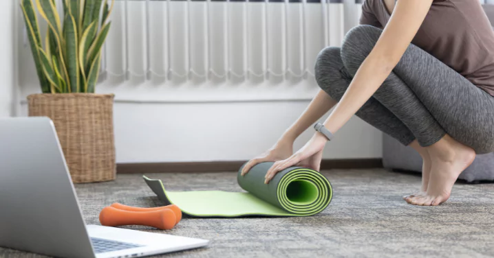 woman rolling out the training mat after a session of training "weight loss"